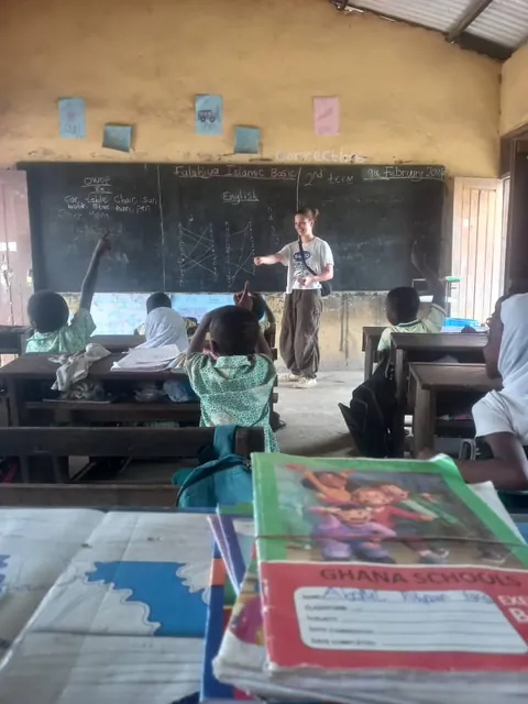Sala de clases en Ghana con un participante frente a la pizarra