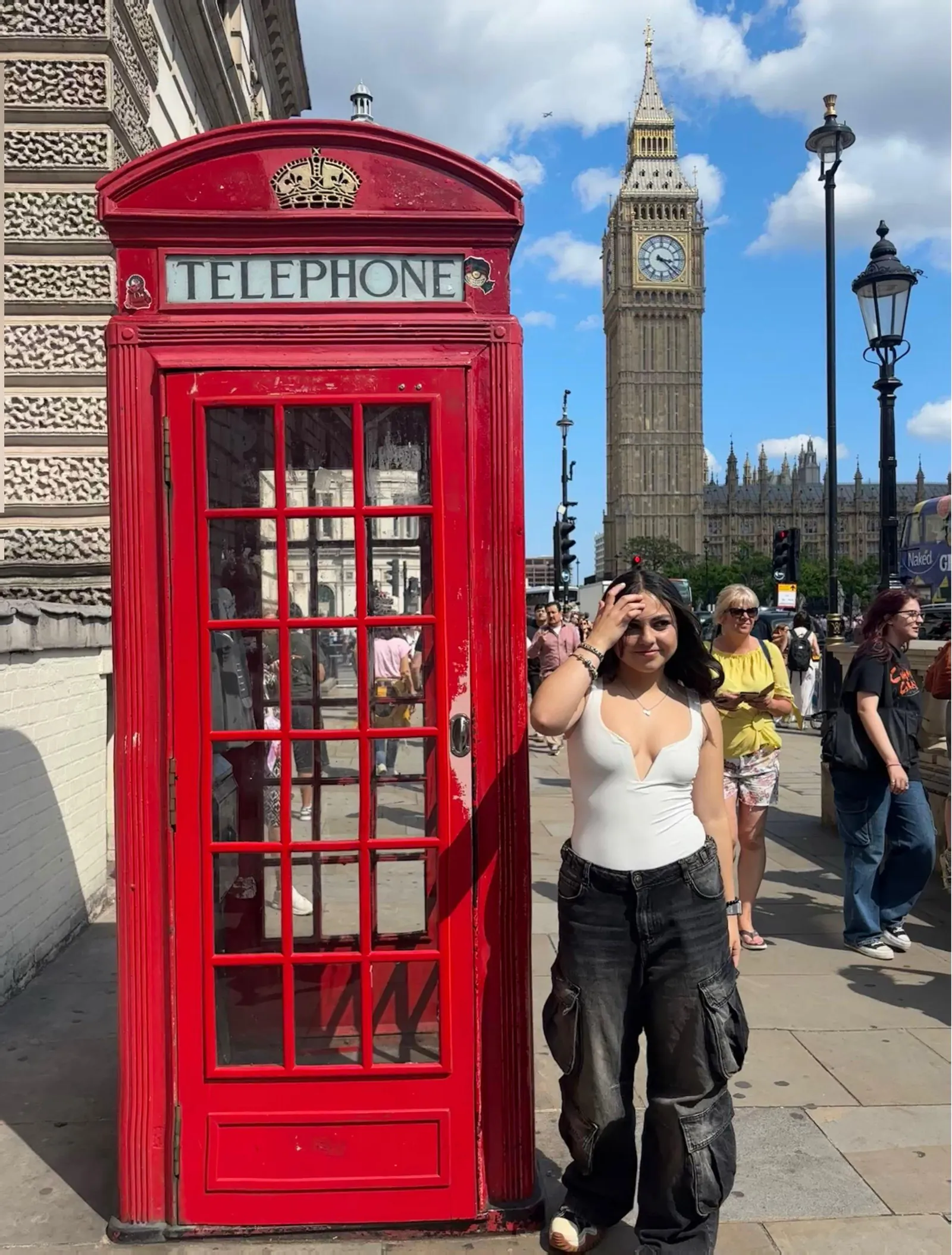Participante junto a una cabina telefónica roja y el Big Ben en Londres